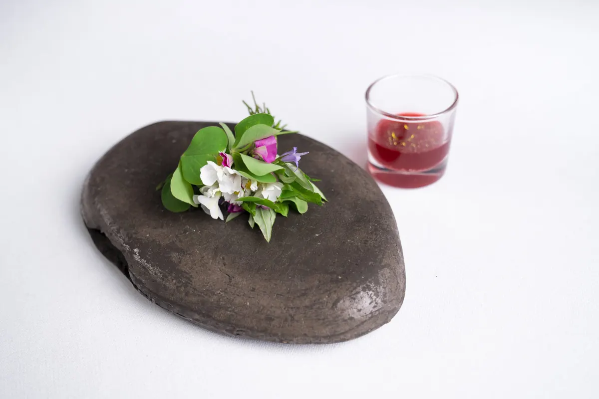 Piccolo pinzimonio di aceto di kombucha e olio di sesamo con bouquet di fiori, erbe e verdure selvatiche